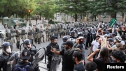 Agentes de policía hacen guardia mientras los manifestantes participan en una protesta cerca de la Casa Blanca contra la muerte bajo custodia policial de George Floyd en Minneapolis.