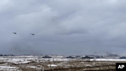 En esta foto tomada de un video y publicada por el Servicio de Prensa del Ministerio de Defensa de Rusia el miércoles 2 de febrero de 2022, tanques y helicópteros militares rusos y bielorrusos asisten a ejercicios militares conjuntos en el campo de tiro de Brestsky, Bielorrusia.