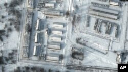 Esta imagen satelital muestra un primer plano de vehículos blindados de transporte de personal y camiones en las instalaciones de almacenamiento de Klimovo en Rusia, 13 kilómetros al norte de la frontera entre Rusia y Ucrania, el 19 de enero de 2022.
