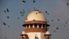FILE- Merpati terbang melewati kubah gedung Mahkamah Agung India di New Delhi, India, 2 Februari 2016.