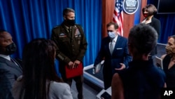 El portavoz del Pentágono, John Kirby, centro derecha, habla con los reporteros al salir de una sesión informativa en el Pentágono en Washington, el miércoles 25 de agosto de 2021.