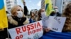 Ucranianos residentes en Japón sostienen pancartas y banderas durante una manifestación de protesta denunciando a Rusia por sus acciones en Ucrania, cerca de la embajada rusa en Tokio, Japón, el 23 de febrero de 2022.