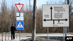 Un hombre pasa junto a una señal de tráfico en la ciudad de Avdiivka, región de Donetsk, ubicada en la línea del frente con los separatistas respaldados por Rusia, el 21 de febrero de 2022.
