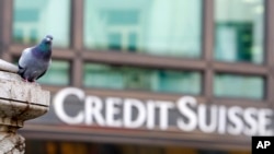 En esta fotografía de archivo del martes 27 de octubre de 2009, una paloma descansa cerca de un edificio que alberga las oficinas del banco Credit Suisse en Milán, Italia.