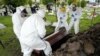 Trabajadores funerarios levantan un ataúd que contiene los restos de un hombre que murió de COVID-19, en el Cementerio Parque Zipaquirá en Zipaquirá, Colombia, el viernes 18 de junio de 2021