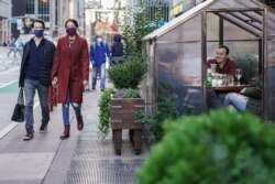 Comensales dentro de una parte de la acera cubierta por plástico en un restaurante mientras observan los protocolos de distanciamiento social para combatir la propagación del COVID-19, el sábado 14 de noviembre de 2020 en Nueva York.