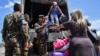 FILE - Venezuelans get off a Brazilian army truck after being given a ride by Brazilian soldiers while crossing the Brazilian-Venezuelan border, into Pacaraima, Roraima state, Brazil, Feb. 27, 2019.