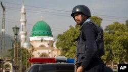 ARCHIVO - Un oficial de policía pakistaní monta guardia fuera del santuario de Barri Imam, mientras se intensifica la seguridad en la capital luego de un ataque suicida en un santuario sufí en Sindh, Islamabad, Pakistán.