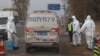 FILE - Workers disinfect passing vehicles in an area after the latest incident of African swine flu outbreak on the outskirts of Beijing, China, Nov. 23, 2018.