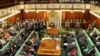 Uganda's Prime Minister, standing center-left, addresses Members of Parliament in Kampala, Uganda, Sept. 21, 2017.