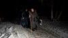 Žene sa prtljagom prelaze granicu sa Rusijom u ukrajinskom regionu Sumi. (Foto: AP/Hanna Arhirova)
