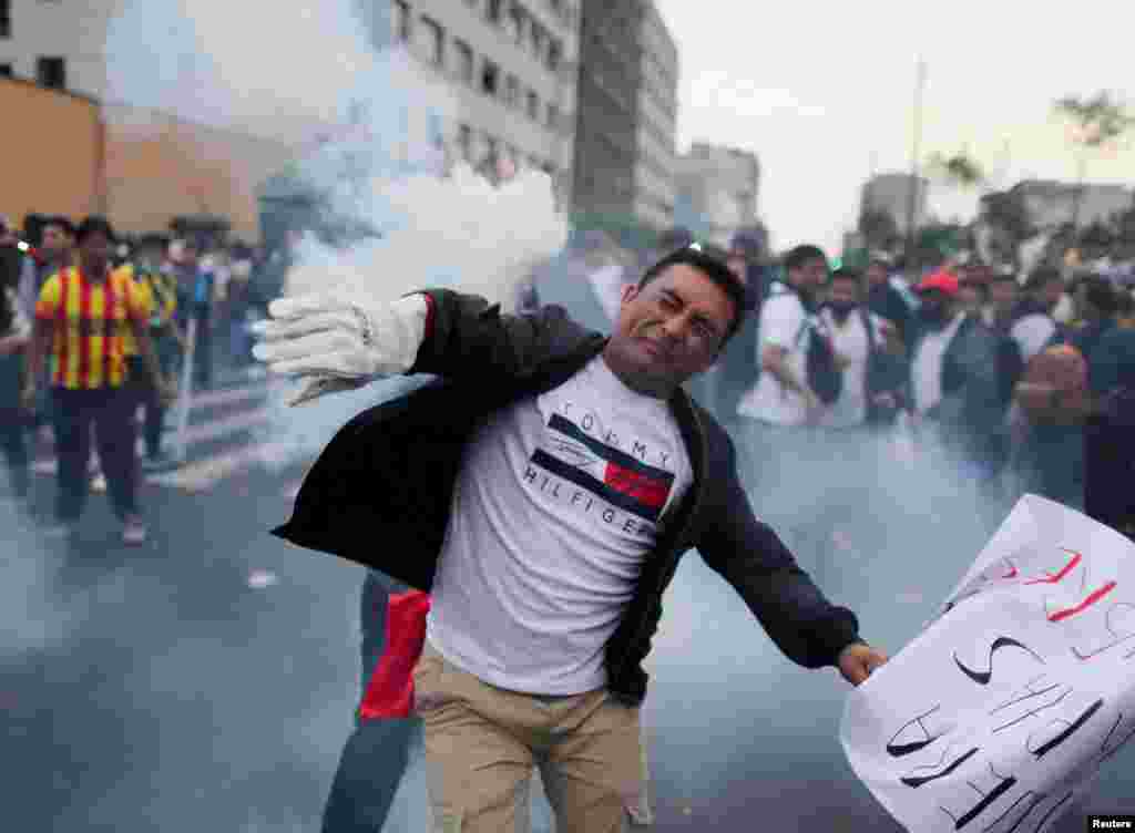 Un manifestante devuelve un bote de gas lacrimógeno durante una protesta que exige elecciones presidenciales y el cierre del Congreso después de que el derrocado líder peruano Pedro Castillo fuera detenido en una prisión policial tras su destitución, en Lima, Perú, el 8 de diciembre de 2022. REUTERS/Sebastian Castaneda