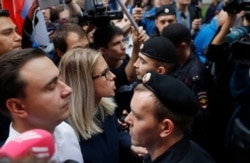 FILE - Russian opposition candidate and lawyer at the Foundation for Fighting Corruption Lyubov Sobol, center, and others stand in front of a police line during a protest in Moscow, Russia, July 14, 2019.