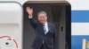El primer ministro chino, Li Qiang, saluda a los miembros de los medios a su llegada para reuniones trilaterales en el aeropuerto de Seúl en Seongnam, Corea del Sur, el domingo 26 de mayo de 2024.