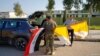 Voluntarios sostienen banderas iraquíes y vaticanas mientras decoran las calles de cara a la visita del Papa Francisco, en Qaraqosh, Iraq, el 22 de febrero del 2021.