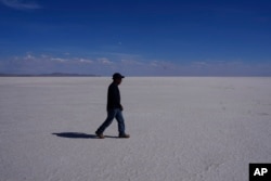 Un hombre camina por el salar de Uyuni, en las afueras de Llipi, Bolivia, el viernes 15 de diciembre de 2023. El gobierno de Bolivia inauguró el mismo día su primera planta de litio de mediana escala financiada por el Estado en el salar.