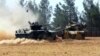 A Turkish army tank and an armored vehicle are stationed near the border with Syria, in Karkamis, Turkey, Aug. 23, 2016. Turkish media reports say Turkish artillery on Tuesday launched new strikes at Islamic State targets across the border in Syria.