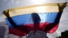 ARCHIVO - Un familiar de un preso en huelga de hambre sostiene una bandera venezolana durante una protesta en la avenida Bolívar en Caracas, Venezuela, el miércoles 12 de junio de 2024.