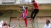 Garment workers from textile company Envoy Group demonstrate climbing a makeshift ladder, which serves as a fire exit to the building, during a protest in Dhaka, June 10, 2013. 