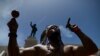 Gypsy Córdova exhala humo y sacude una maraca frente a un monumento a Juan Ponce de León, en una protesta para que se retiren los monumentos a colonizadores españoles en Puerto Rico.
