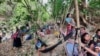 ကေအဲန်ယူတပ်မဟာ ၆ နယ်မြေထဲ တပ်တွေတိုးချလာနေတာကြောင့် စစ်ရှောင်ဒုက္ခသည်တွေ အိမ်မပြန်နိုင်သေးကြောင်း ကေအဲန်ယူပြောခွင့်ရက ပြောပါတယ်။  မြန်မာစစ်တပ် ဗုံးကြဲတိုက်ခိုက်မှုကြောင့် တိမ်းရှောင်နေတဲ့ စစ်ဘေးရှောင်ကရင်ဒုက္ခသည်များ (ယခင်ပုံဟောင်း) (ဓာတ်ပုံ - KNU )