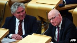 John Swinney, right, of the Scottish National Party attends the Scottish Parliament in Edinburgh on April 30, 2024. Swinney has said he is considering running for first minister now that Humza Yousaf has announced his resignation.