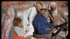 FILE - An undated photo released Oct. 14, 2017, shows family members watching Australia's most famous Aboriginal artist, Albert Namatjira, sitting on a rock as he paints.