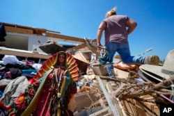 Una estatua de la Virgen de Guadalupe yace entre los escombros de la casa destruida de Juana Landeros, quien resistió un tornado mortal con su esposo y su hijo de 9 años la noche anterior, el domingo 26 de mayo de 2024, en Valley View, Texas, EEUU.