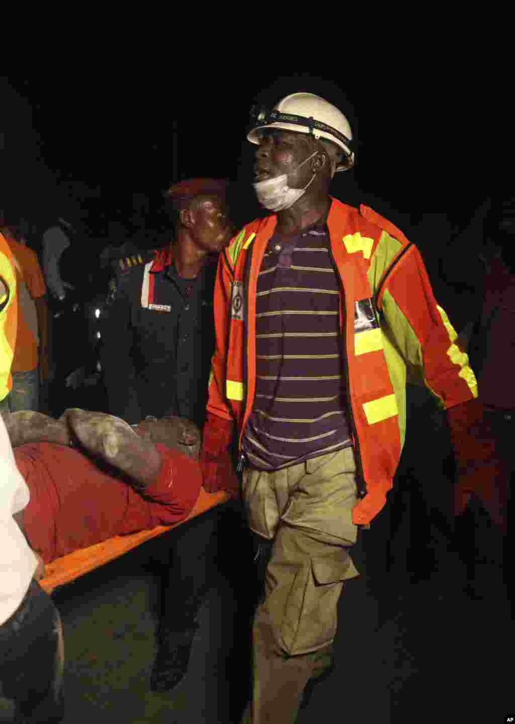 Rescue workers carry a survivor from the rubble of a building under construction which collapsed in Lagos, Nigeria, Nov, 4. 2013.