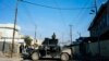 FILE - A member of the Iraqi special forces' Counter-Terrorism Service (CTS) stands on the top of a Humvee as demining experts search for booby-trapped buildings in eastern Mosul, Iraq, Jan. 16, 2017.