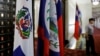 A police officer stands next to the Dominican Republic flag, left, inside the Taiwan's Ministry of Foreign Affairs in Taipei, Taiwan, May 1, 2018. 