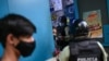 Miembros de la policía nacional ordenan al dueño de un negocio cerrar su tienda durante una cuarentena ordenado por el gobierno para frenar la propagación de COVID-19 en Caracas, el 21 de mayo de 2021.
