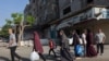 Palestinos llevando sus pertenencias huyen a áreas más seguras en la Ciudad de Gaza después de ataques aéreos isaelíes el 13 de octubre de 2023.
