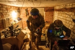 Un soldado ucraniano, también conocido como Manul, del batallón ACHILLES de la 92.a brigada, lleva un dron suicida FPV a la posición de despegue antes de sobrevolar posiciones rusas en la región de Járkov, Ucrania, el lunes 13 de mayo de 2024. (Foto AP/Evgeniy Maloletka)