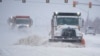 Camiones despejan la nieve acumulada en una autopista en Oklahoma City, Oklahoma, el 14 de febrero de 2021.