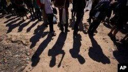 ARCHIVO - Migrantes aguardan a ser procesados tras cruzar la frontera entre México y EEUU, en Eagle Pass, el 19 de octubre de 2023.