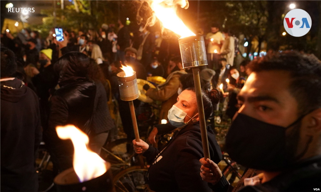 Las personas sostienen antorchas en una vigilia en honor a los que murieron durante las protestas contra el Gobierno. Bogot&#225;, Colombia, 6 de mayo de 2021.