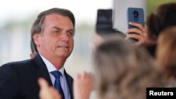 El presidente de Brasil posa para fotos de seguidores al salir del Palacio de la Alvorada en Brasilia, el 12 de diciembre de 2019. Foto REUTERS/Adriano Machado.