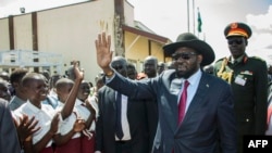 South Sudan President Salva Kiir waves as he greets schoolchildren at Juba International Airport in Juba on Sept. 13, 2018.