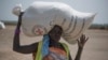 A woman walks back to her home after receiving food distributed by the Red Cross in South Sudan, April 11, 2017.
