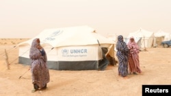 FILE - Libyan women displaced from the town of Tawergha are seen at a camp in the Garart al-Gatef, Libya, March 25, 2018. 