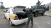 A policeman checks a car at a checkpoint near the U.S. embassy in Sanaa, Yemen, Aug. 6, 2013.