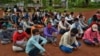 FILE - Migrant workers from Bihar state, wearing masks as a precaution against the coronavirus, wait for buses to catch home bound train in Kochi, southern Kerala state, India, June 12, 2020.