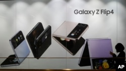 Una mujer pasa frente a un anuncio del Galaxy Z Flip4 de Samsung Electronics en su tienda en Seúl, Corea del Sur, el martes 31 de enero de 2023. (Foto AP/Ahn Young-joon)