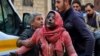 Syrian men help a wounded woman covered in dust following a strike in the town of Khan Shaykhun in the southern countryside of the rebel-held Idlib province, Feb. 15, 2019.