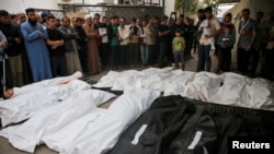 Los dolientes rezan y se reúnen cerca de los cuerpos de los palestinos muertos en ataques israelíes, en medio del conflicto en curso entre Israel y el grupo islamista palestino Hamás, durante su funeral en Rafah, en el sur de la Franja de Gaza, el 29 de abril de 2024.