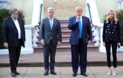 El presidente Trump posa junto a miembros de su gabinete y su secretaria de prensa delante de la Iglesia Episcopal de San Juan, frente a la Casa Blanca. El mandatario sostiene una biblia.