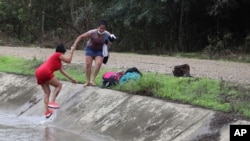 Migrantes venezolanos regresan al lado ecuatoriano de la frontera después de que los soldados peruanos los detuvieran, visto desde Tumbes, Perú, el 29 de enero de 2021.