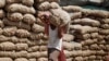 An Indian laborer carries a sack of onions at a warehouse in Jammu, India, August 22, 2013.