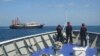 FILE - In this April 27, 2021, photo provided by the Philippine coast guard, its personnel patrol beside ships said to be Chinese militia vessels at Sabina Shoal in the South China Sea. The Philippines said on May 11, 2024, China is building "an artificial island" at the shoal.